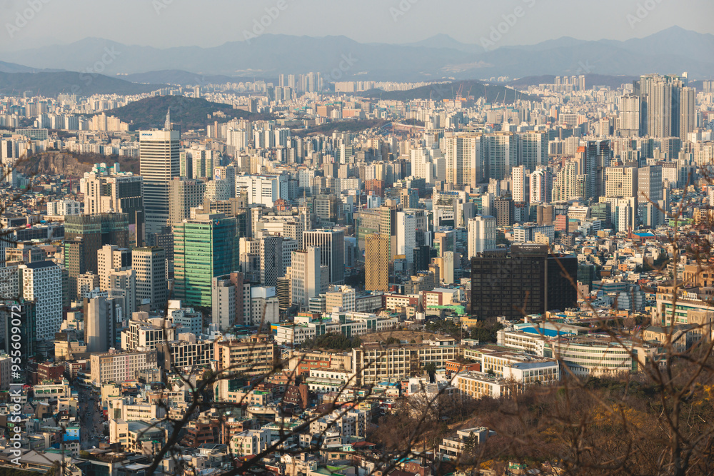 Naklejka premium Beautiful vibrant aerial sunset view of Seoul, South Korea skyline, with mountains and sprin scenery beyond the city, seen from observation deck of Namsan Park, Gyeonggi-do province, Republic of Korea
