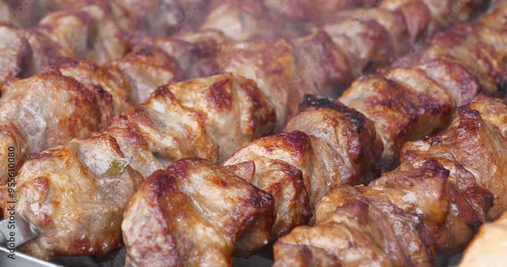 Shish kebabs broil on barbecue. Meat are cooked on hot coals in barbecue, rotates on skewers for roasting. Delicious hot meat Shish kebabs broil on barbecue. Meat are cooked on hot coals in barbecue, rotates on skewers for roasting. Delicious hot meat