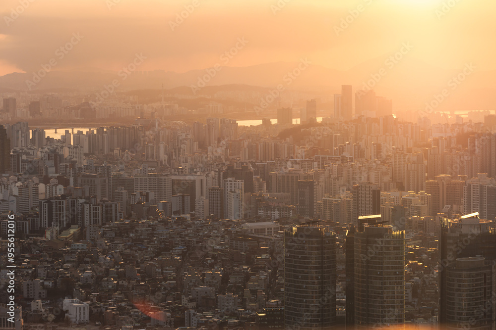 Fototapeta premium Beautiful vibrant aerial sunset view of Seoul, South Korea skyline, with mountains and sprin scenery beyond the city, seen from observation deck of Namsan Park, Gyeonggi-do province, Republic of Korea