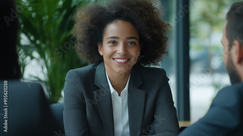 Smiling businesswoman having pleasant conversation during meeting with colleagues