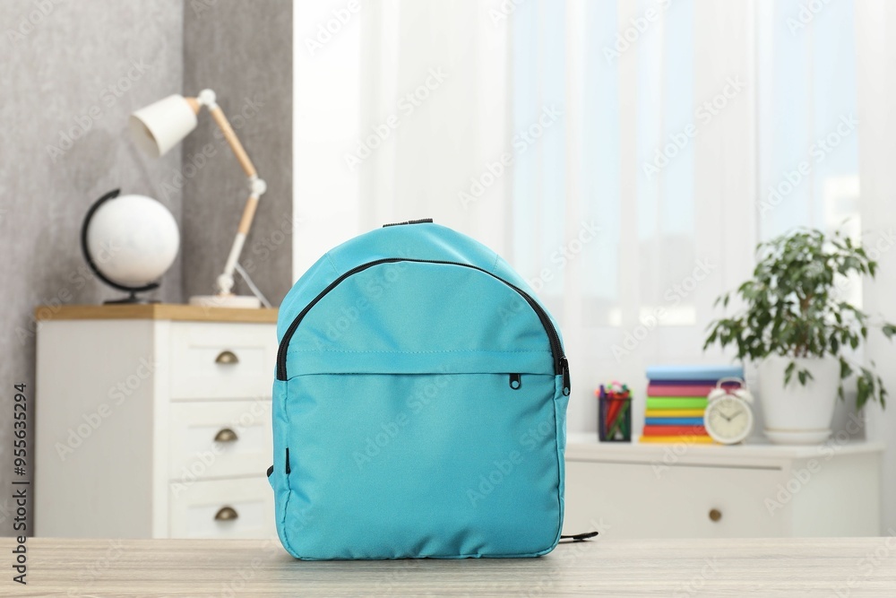 Light blue backpack on desk in room Light blue backpack on desk in room