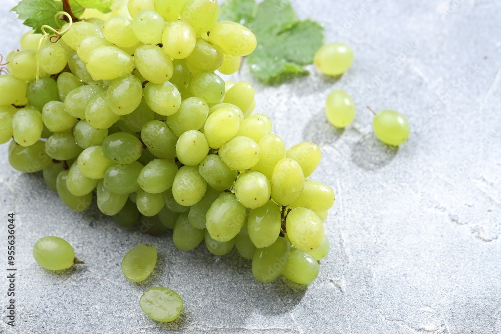 Fresh ripe grapes on grey table, closeup Fresh ripe grapes on grey table, closeup