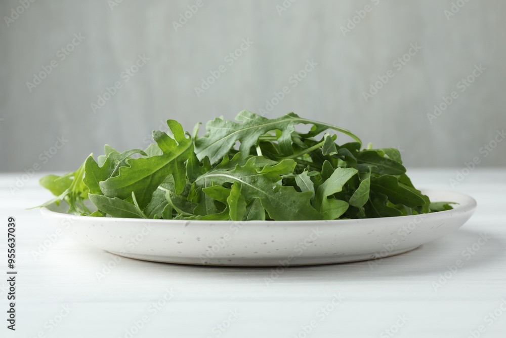 Fresh green arugula leaves on white table, closeup Fresh green arugula leaves on white table, closeup