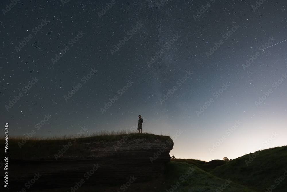 Night scene, a man with a night vision device stands on a cliff. The starry sky and the milky way. Night scene, a man with a night vision device stands on a cliff. The starry sky and the milky way.