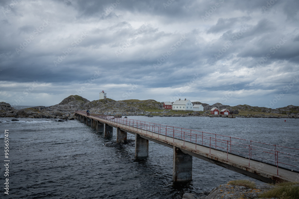 Obraz premium Footwalk concrete bridge over rough sea towards light house in Norway