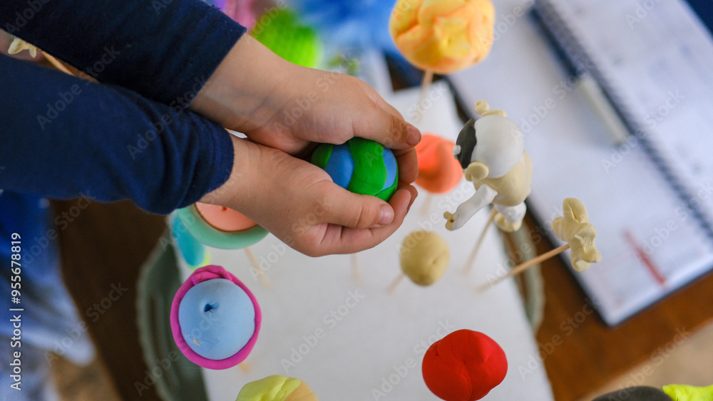 Child's hand holding plasticine planet earth, ecology concept Child's hand holding plasticine planet earth, ecology concept