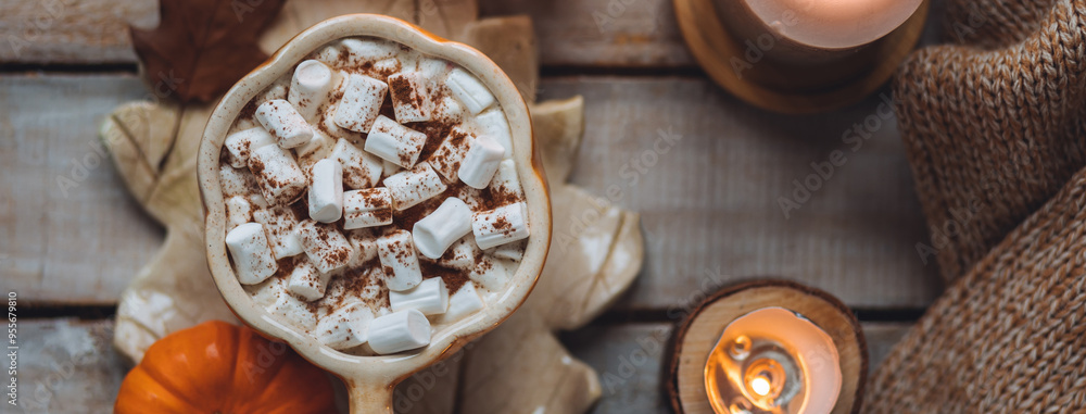 Flat lay top view. Spicy sweet fall hot drink: delicious pumpkin latte with cinnamon, marshmallow. Served in handmade artisan mug in shape of pumpkins, cozy home decor with candles, dry leaves banner Flat lay top view. Spicy sweet fall hot drink: delicious pumpkin latte with cinnamon, marshmallow. Served in handmade artisan mug in shape of pumpkins, cozy home decor with candles, dry leaves banner