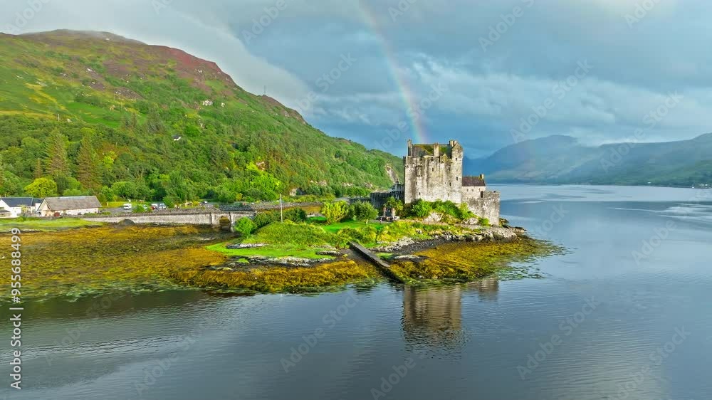 Aerial view of a rainbow over Eilean Donan Castle with long arched bridge and lochside setting. Scottish icon and a popular tourist attraction in the Highlands overlooking the Isle of Skye. Aerial view of a rainbow over Eilean Donan Castle with long arched bridge and lochside setting. Scottish icon and a popular tourist attraction in the Highlands overlooking the Isle of Skye.
