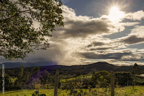 A bright afternoon sun at the edge of a great dark cloud, over the eastern Andean mountains of central Colombia.