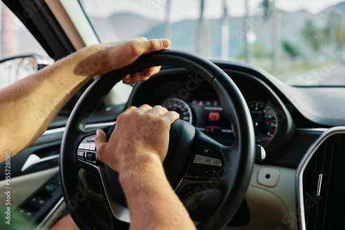 Wallpaper Mural A person holding the steering wheel of a car while driving through a scenic background Torontodigital.ca