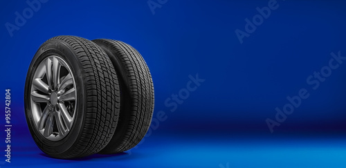 Wallpaper Mural Two car tires with alloy wheels placed on a blue background, offering ample space for text or promotional content Torontodigital.ca