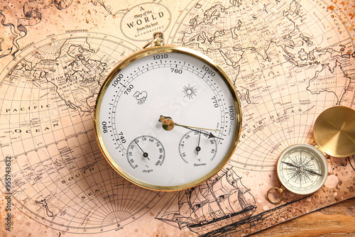 Composition with aneroid barometer and compass on world map. Sailing concept