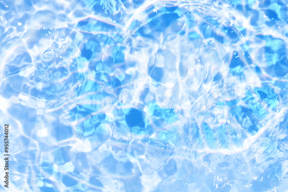 Obraz premium Blue water with ripples on the surface. Defocus blurred transparent blue colored clear calm water surface texture with splashes and bubbles. Water waves with shining pattern texture background.