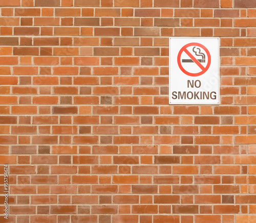No smoking sign attached to a brick built wall anti - smoking symbol.