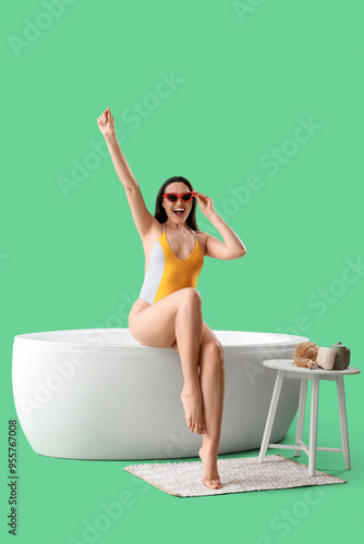 Young woman in swimsuit sit...