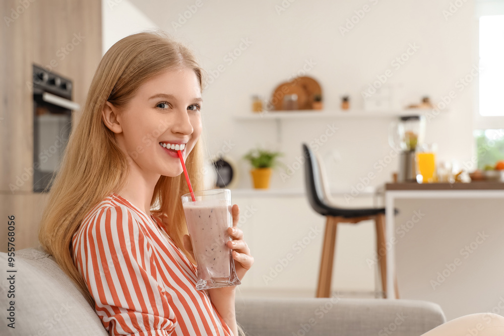 Young woman with healthy smoothie sitting on sofa at home Young woman with healthy smoothie sitting on sofa at home