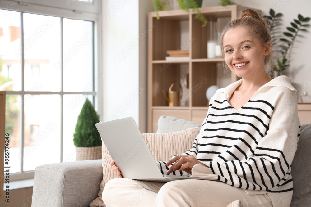 Young woman using modern laptop on sofa at home Young woman using modern laptop on sofa at home