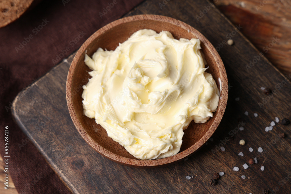 Board with bowl of fresh butter on wooden table, closeup Board with bowl of fresh butter on wooden table, closeup
