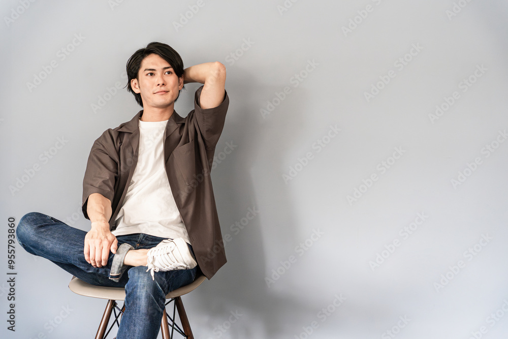 椅子に座るスニーカーとジーンズ姿のさわやかな男性
椅子に座るスニーカーとジーンズ姿のさわやかな男性