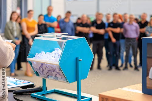 Schilderij op canvas A blue box with a white paper inside is being held by a person, lottery or prize