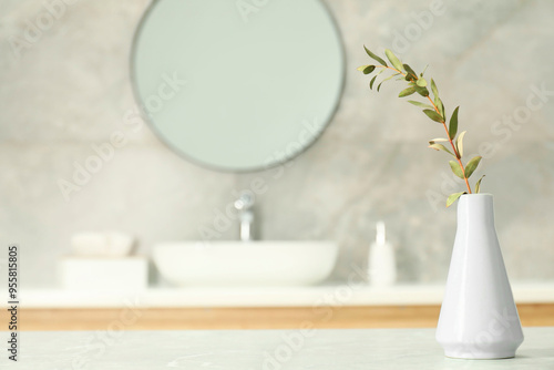 Valokuva Vase with green twig on light grey marble table in bathroom, space for text