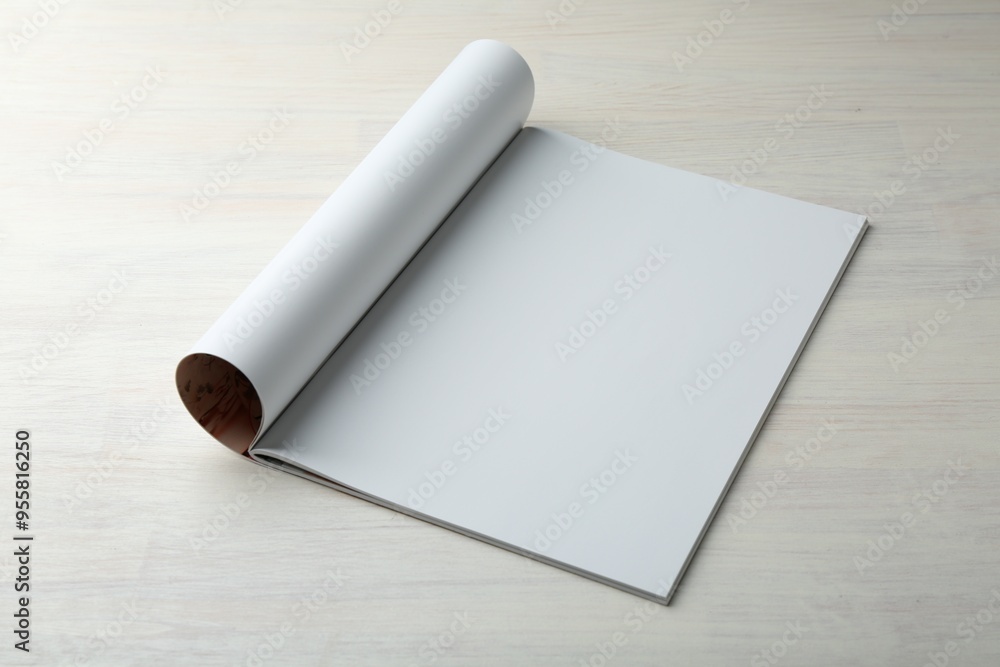 Open magazine with blank page on light wooden table. Mockup for design Open magazine with blank page on light wooden table. Mockup for design