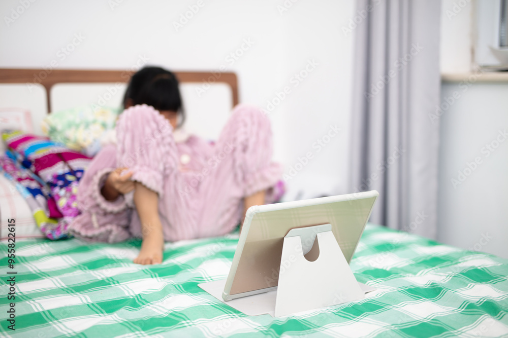 Little girl watching iPad on bed Little girl watching iPad on bed