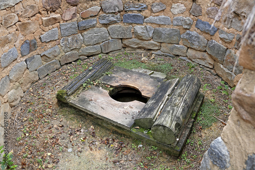 Andong-si, Gyeongsangbuk-do, South Korea - July 31, 2021: High angle and summer view of a wood toilet with hole surrounded by stonewall at Byeongsan Seowon