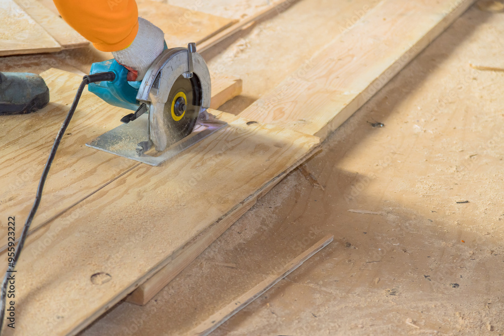 Wooden plywood is being cut with circular saw by worker Wooden plywood is being cut with circular saw by worker