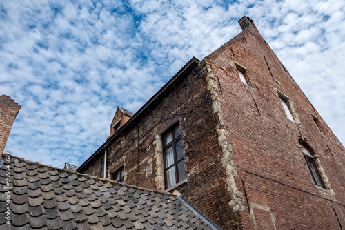 An intricate and detailed old brick building, showcasing a beautifully textured facade against a picturesque sky