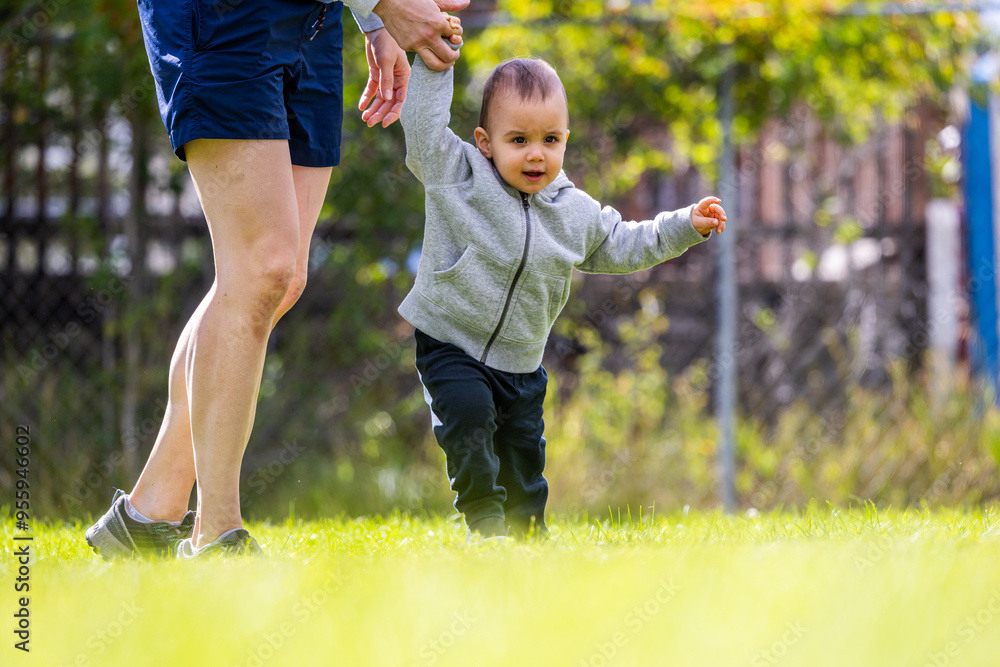 Toddler Learning to Walk with Parent Support in Sunny Park Setting Toddler Learning to Walk with Parent Support in Sunny Park Setting