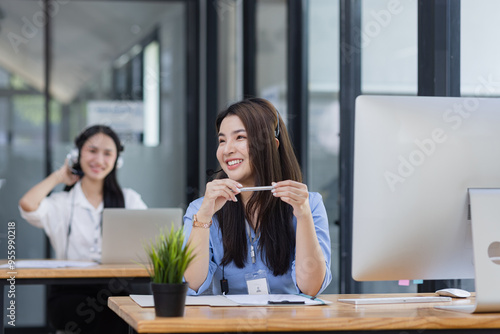 Young asian businesswoman with headset using desktop computer for customer support and online working in office, Call center helping for customers online concept.