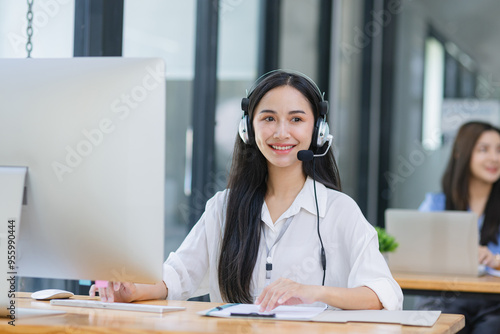 Young asian businesswoman with headset using desktop computer for customer support and online working in office, Call center helping for customers online concept.