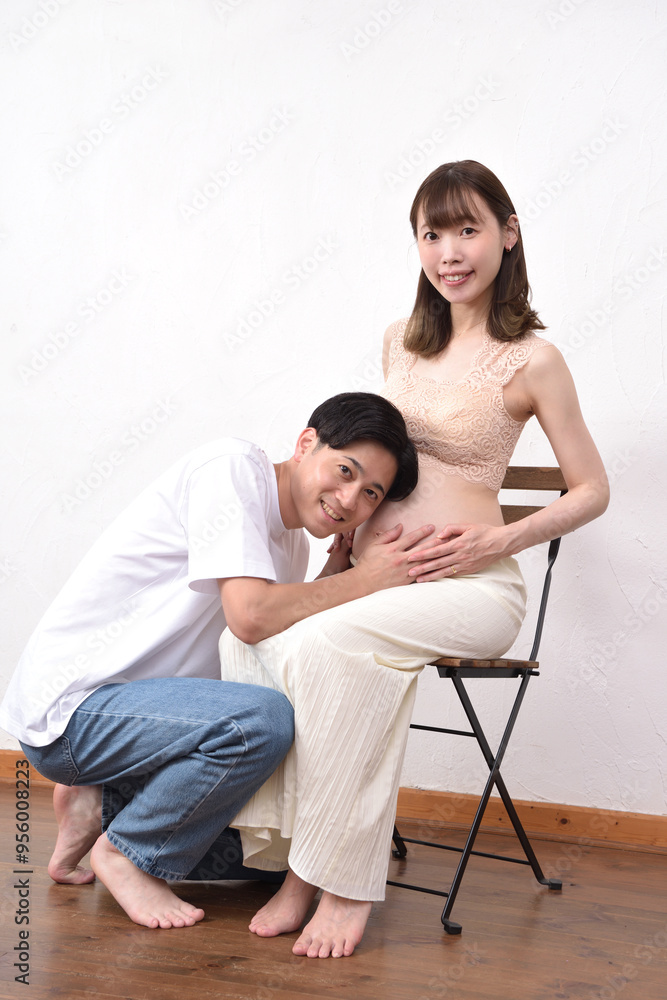 妊娠した大きなお腹の妻に寄り添う若い夫 妊娠した大きなお腹の妻に寄り添う若い夫