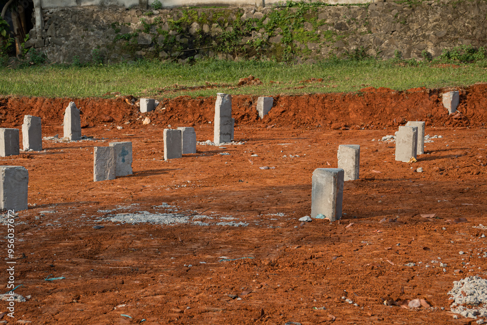 construction site where row of concrete piles or foundation piles have been installed into the ground construction site where row of concrete piles or foundation piles have been installed into the ground