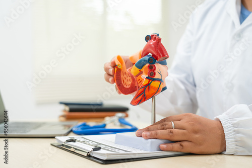 A female doctor works at a desk in the hospital,discussing heart diseases such as coronary artery disease,arrhythmia,heart valve stenosis,heart failure congenital heart disease, emphasizing symptoms