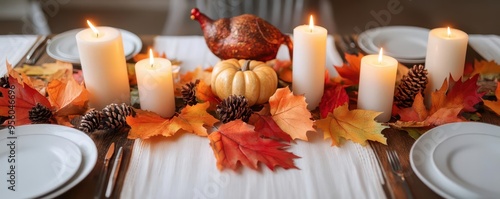 A table decorated for Thanksgiving with autumn leaves, candles, and a turkey centerpiece, Thanksgiving table, autumn leaves, candles photo