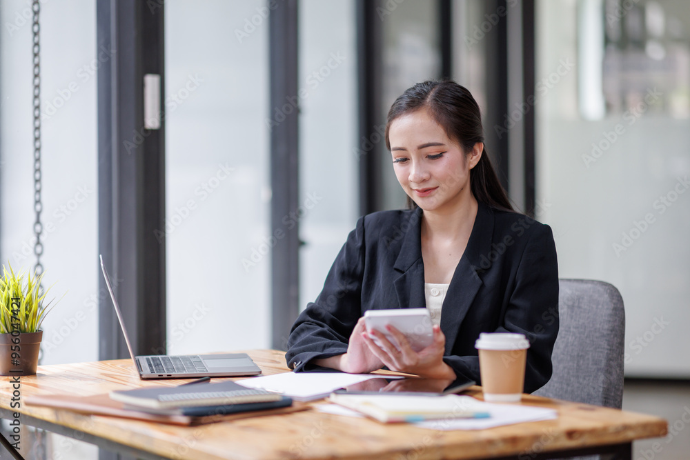 Business woman accountant with documents calculating numbers for a financial audit and taking notes with a silver pen. Taxes and audit concept.