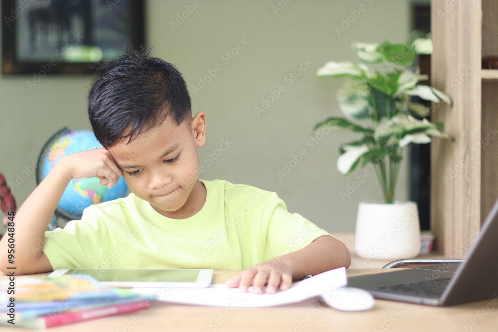 A Happy little asian boy studying online learning class with online video call zoom teacher at home. E-learning or Home schooling education concept. A Happy little asian boy studying online learning class with online video call zoom teacher at home. E-learning or Home schooling education concept.