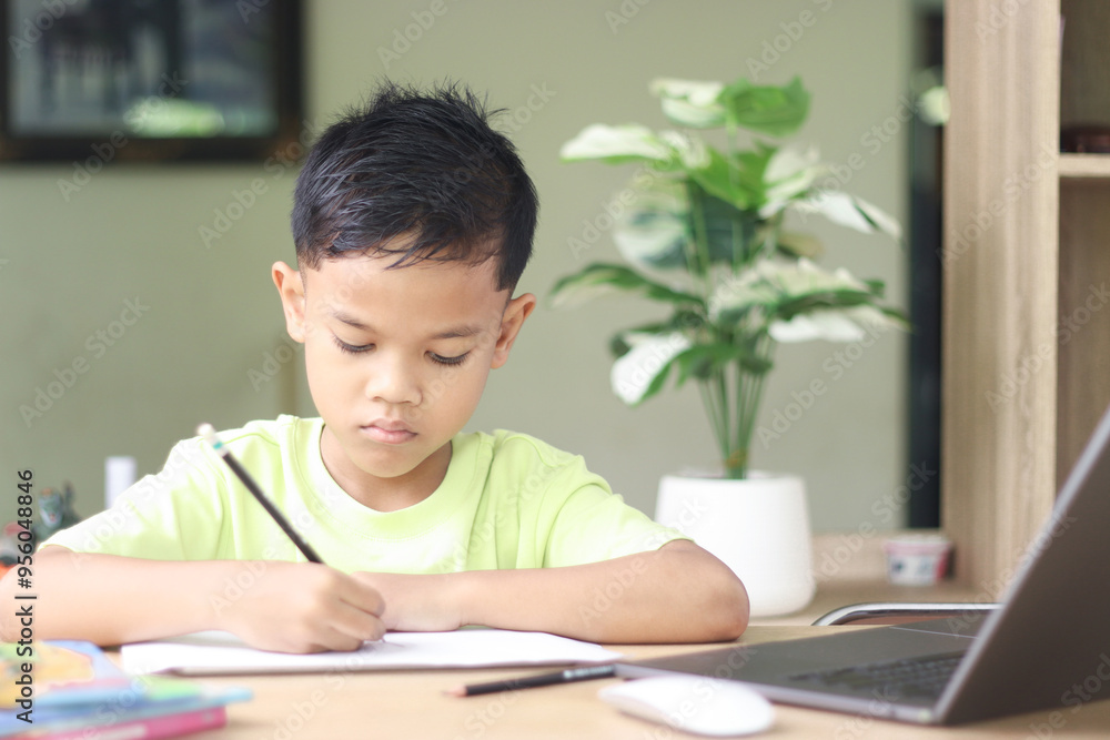 A Happy little asian boy studying online learning class with online video call zoom teacher at home. E-learning or Home schooling education concept. A Happy little asian boy studying online learning class with online video call zoom teacher at home. E-learning or Home schooling education concept.