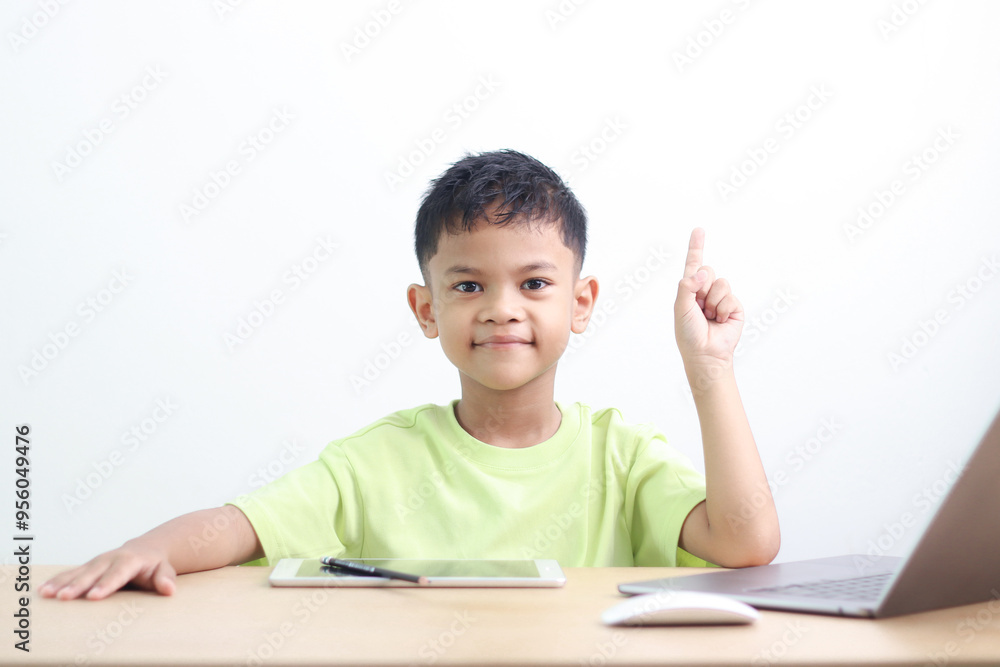 A Happy little asian boy studying online learning class with online video call zoom teacher at home. E-learning or Home schooling education concept. A Happy little asian boy studying online learning class with online video call zoom teacher at home. E-learning or Home schooling education concept.