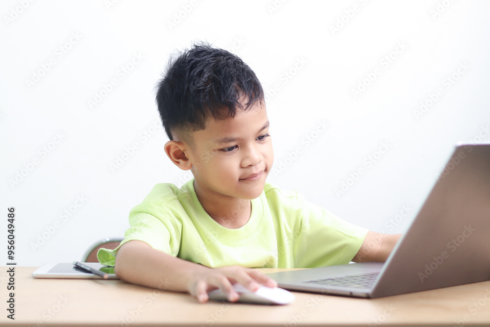 A Happy little asian boy studying online learning class with online video call zoom teacher at home. E-learning or Home schooling education concept. A Happy little asian boy studying online learning class with online video call zoom teacher at home. E-learning or Home schooling education concept.