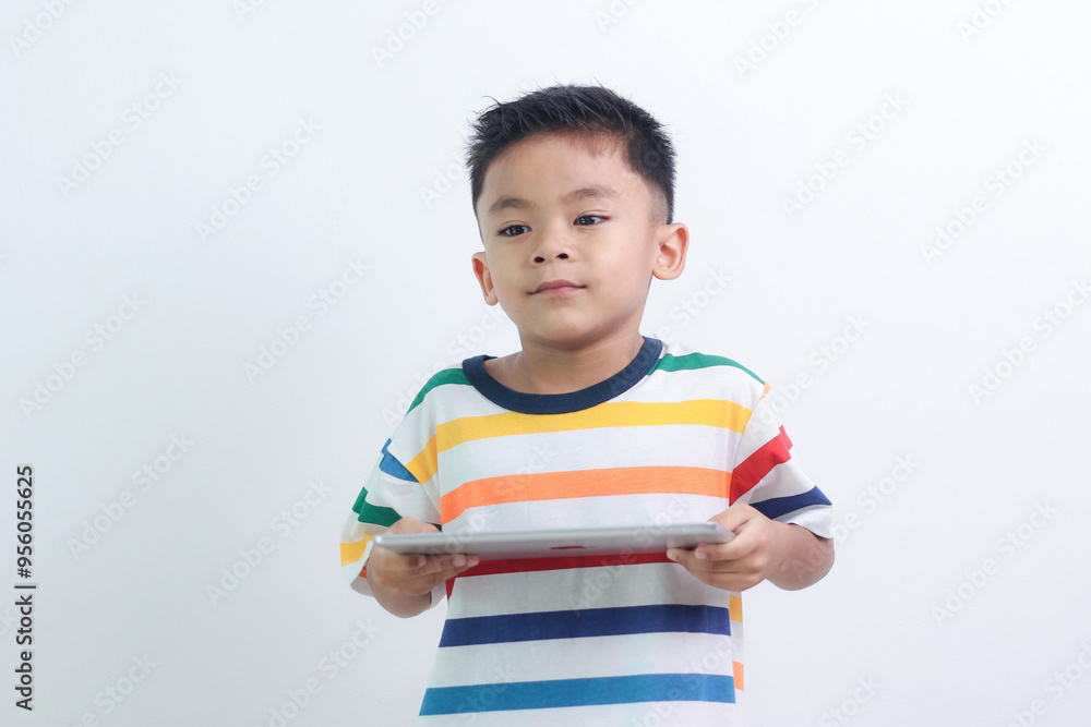 smiling little boy stiiting and holding a tablet. smiling little boy stiiting and holding a tablet.