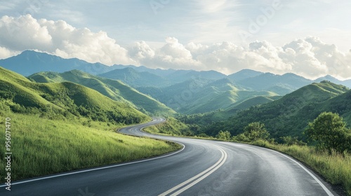 Asphalt road cutting through green mountains, set against a backdrop of morning clouds in the sky