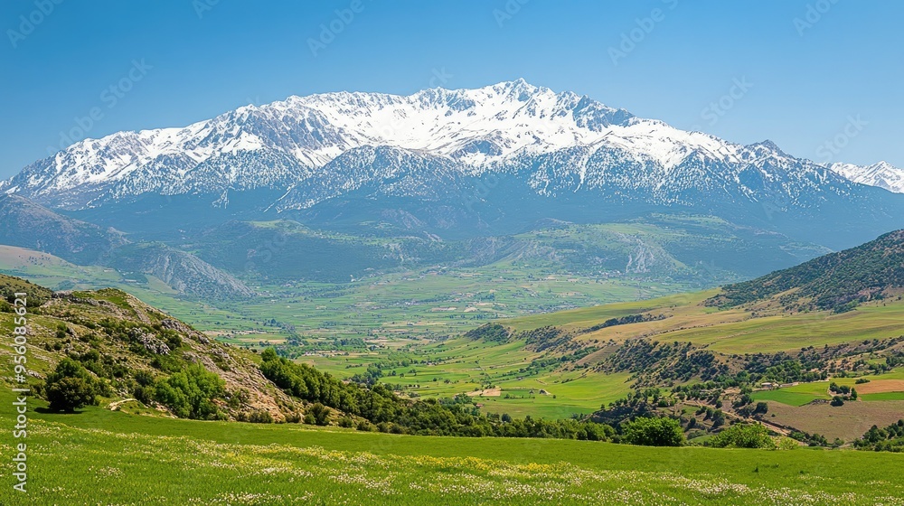Obraz premium The stunning landscape of the Taurus Mountains, with snow-capped peaks and green valleys under a clear sky.