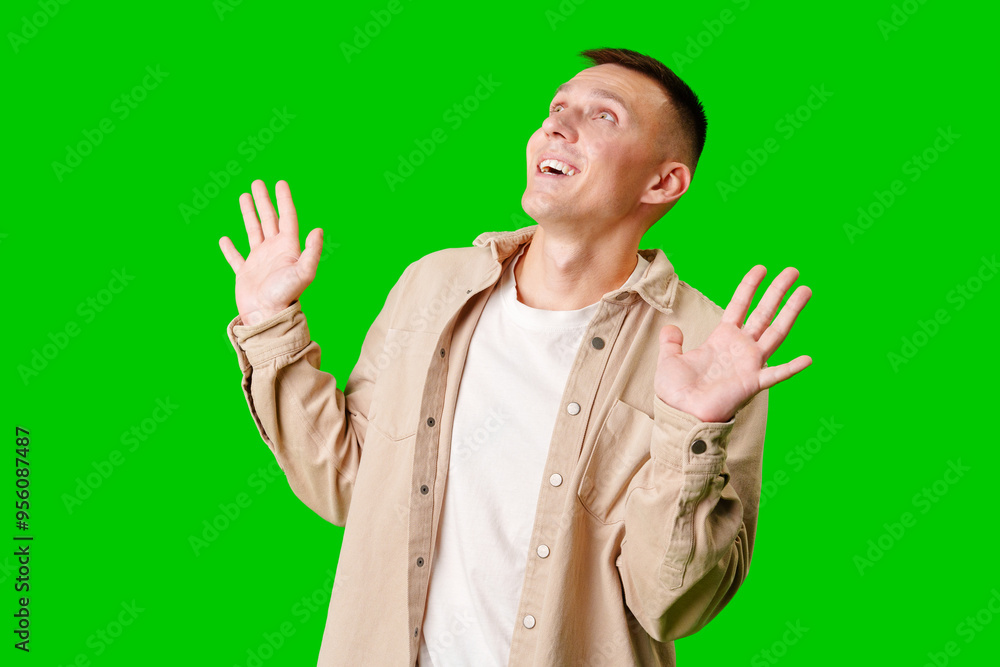 Cheerful Young Man Posing With Outstretched Hands Against a Bright Green Background Cheerful Young Man Posing With Outstretched Hands Against a Bright Green Background