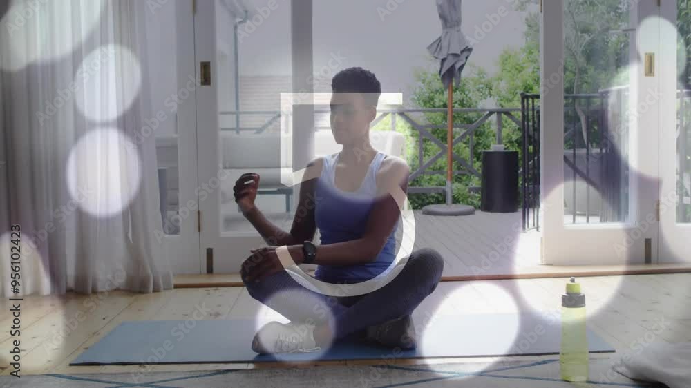 Meditating on yoga mat, person with smartwatch over bokeh lights animation Meditating on yoga mat, person with smartwatch over bokeh lights animation