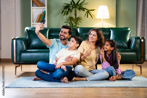 Canvas Print Happy Indian family taking a selfie while sitting on the floor, enjoying new apa