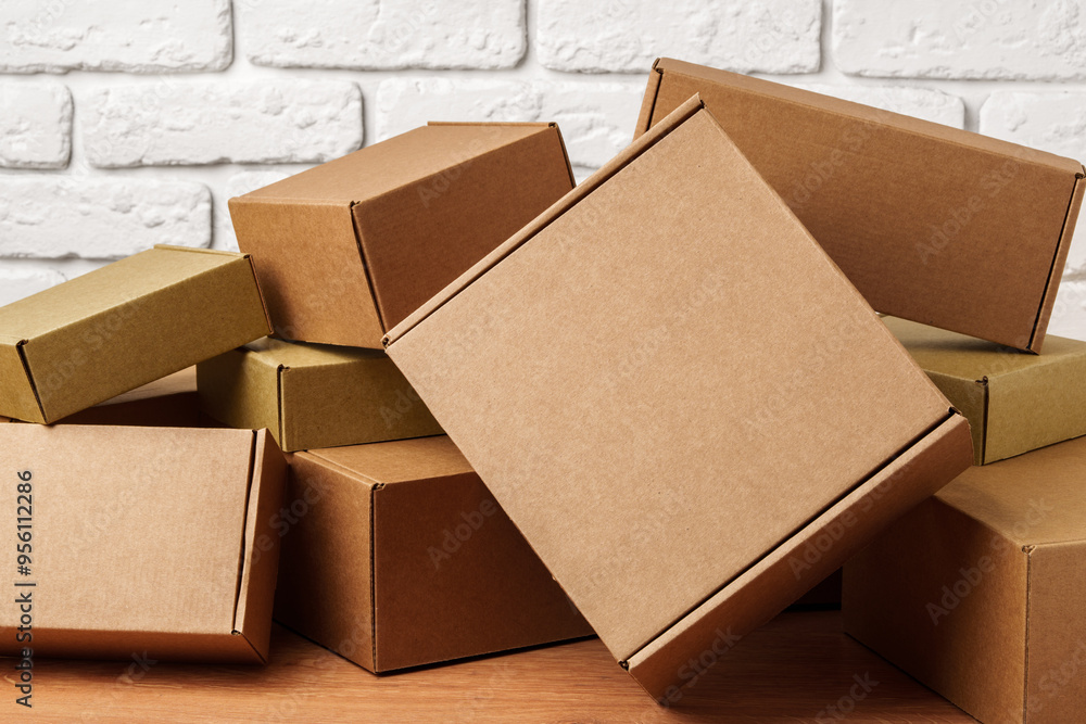 Stacked Cardboard Boxes Against A White Brick Wall Stacked Cardboard Boxes Against A White Brick Wall