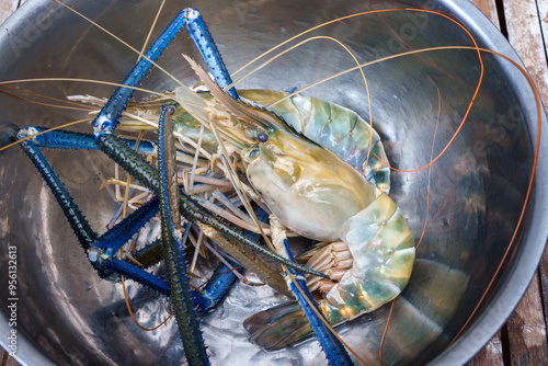 Big Headed fresh Giant river prawns in aluminum tray on the bamboo table premium main ingredients prepared for can cook to grilled shrimp. photo